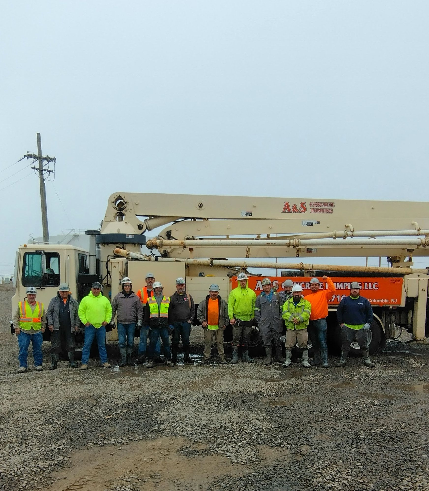 The A&S Concrete Pumping crew standing in front of one of the company’s boom pump trucks