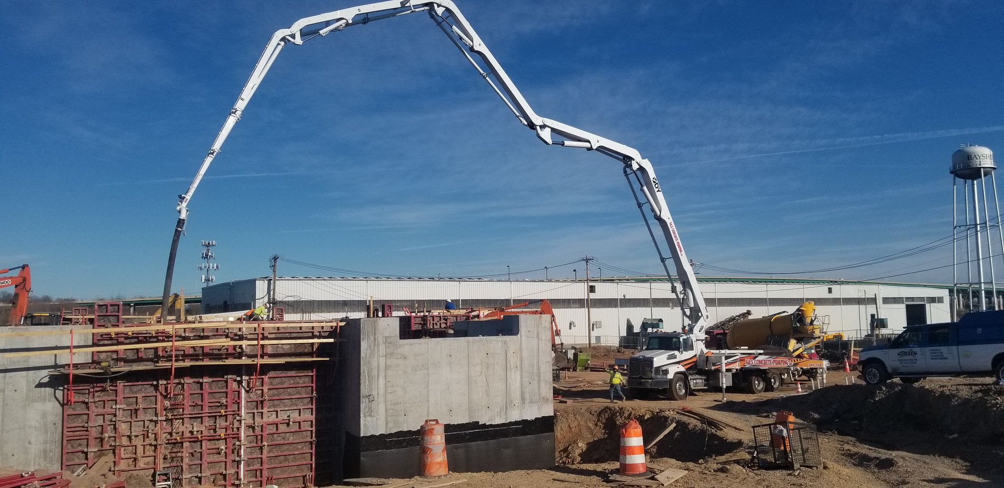 A&S boom pump at full reach over a long concrete wall form