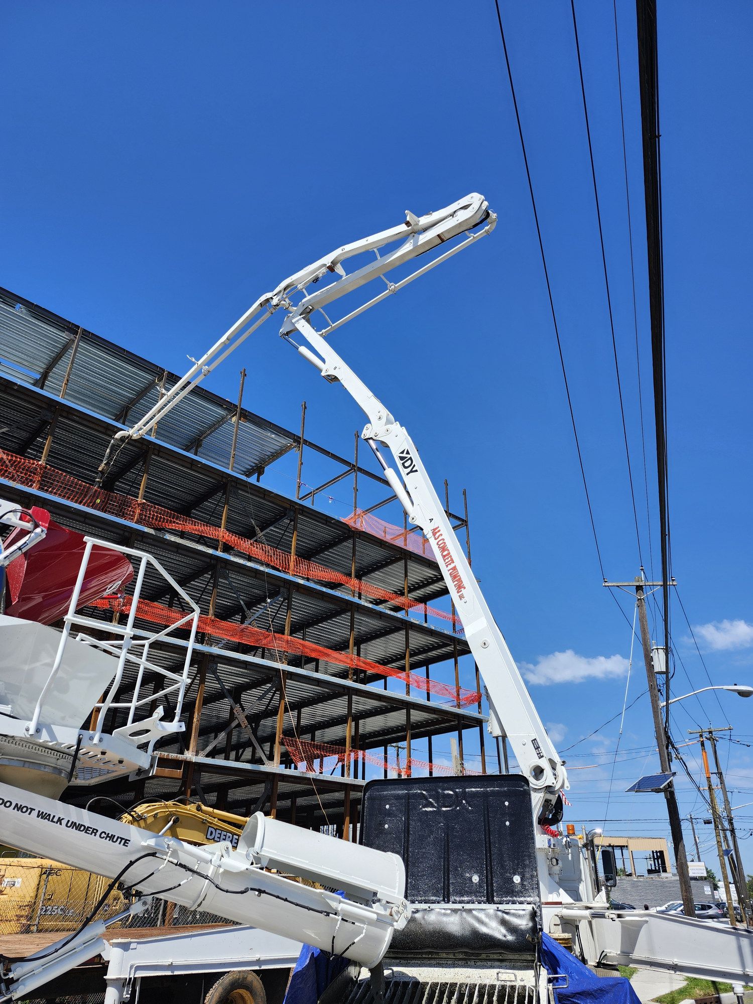 A&S boom pump reaching up over a building under construction