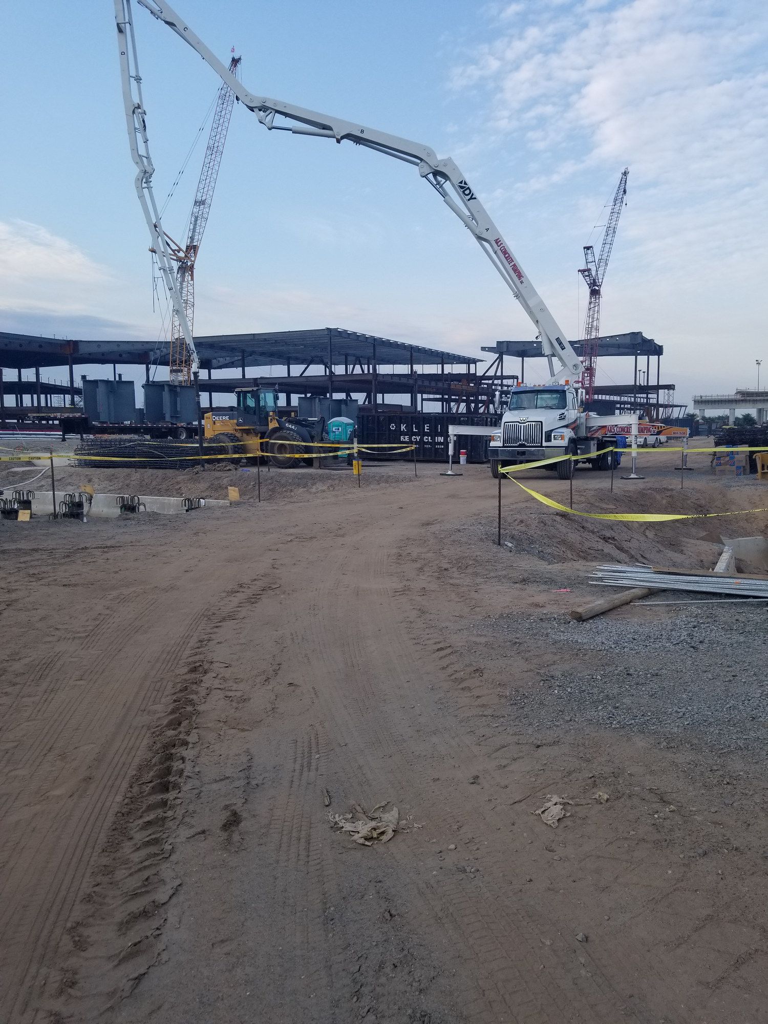 A&S boom pump set up beside steel framing on a large job site