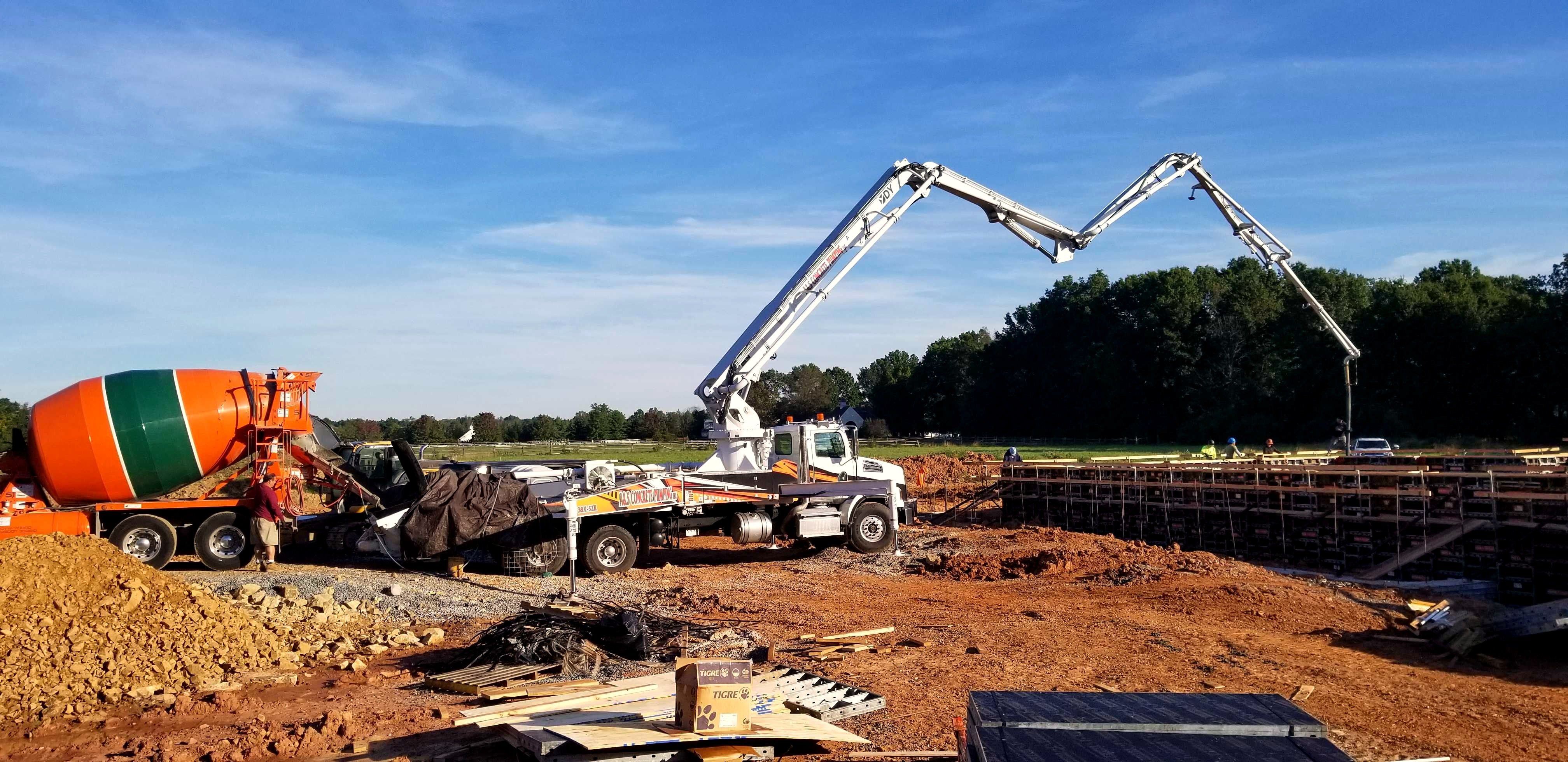 A&S boom pump placing concrete into a long foundation wall form