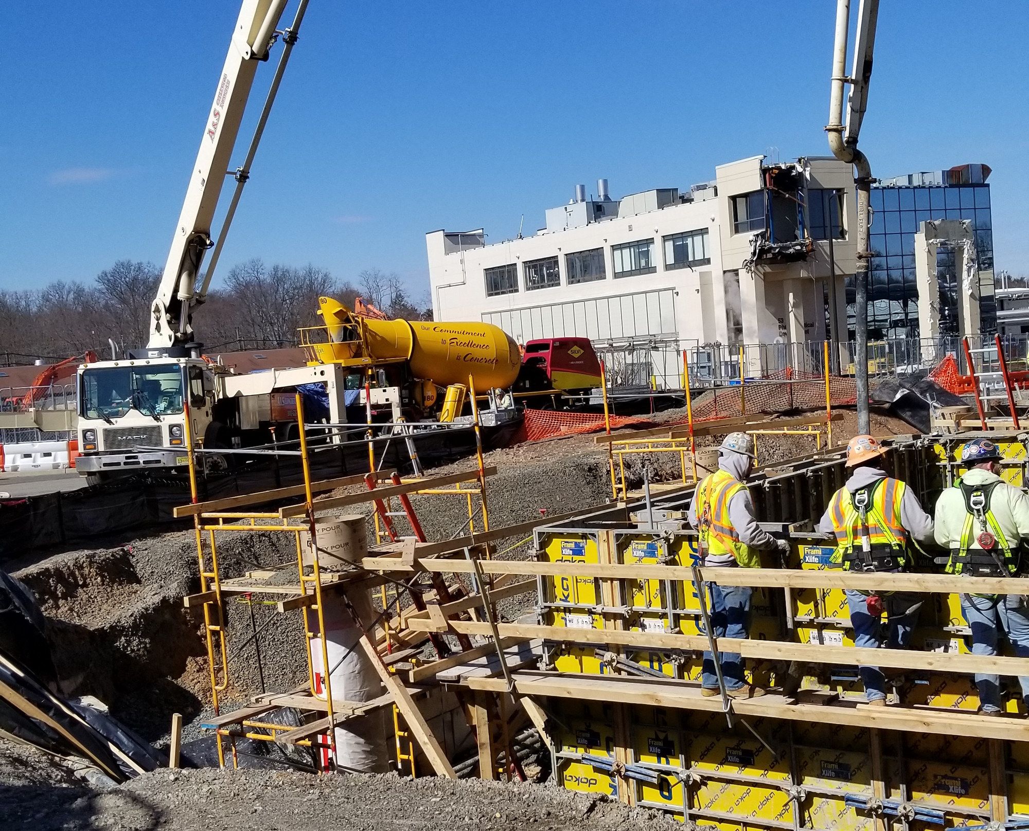 Crew guiding the end hose of an A&S boom pump during a pour
