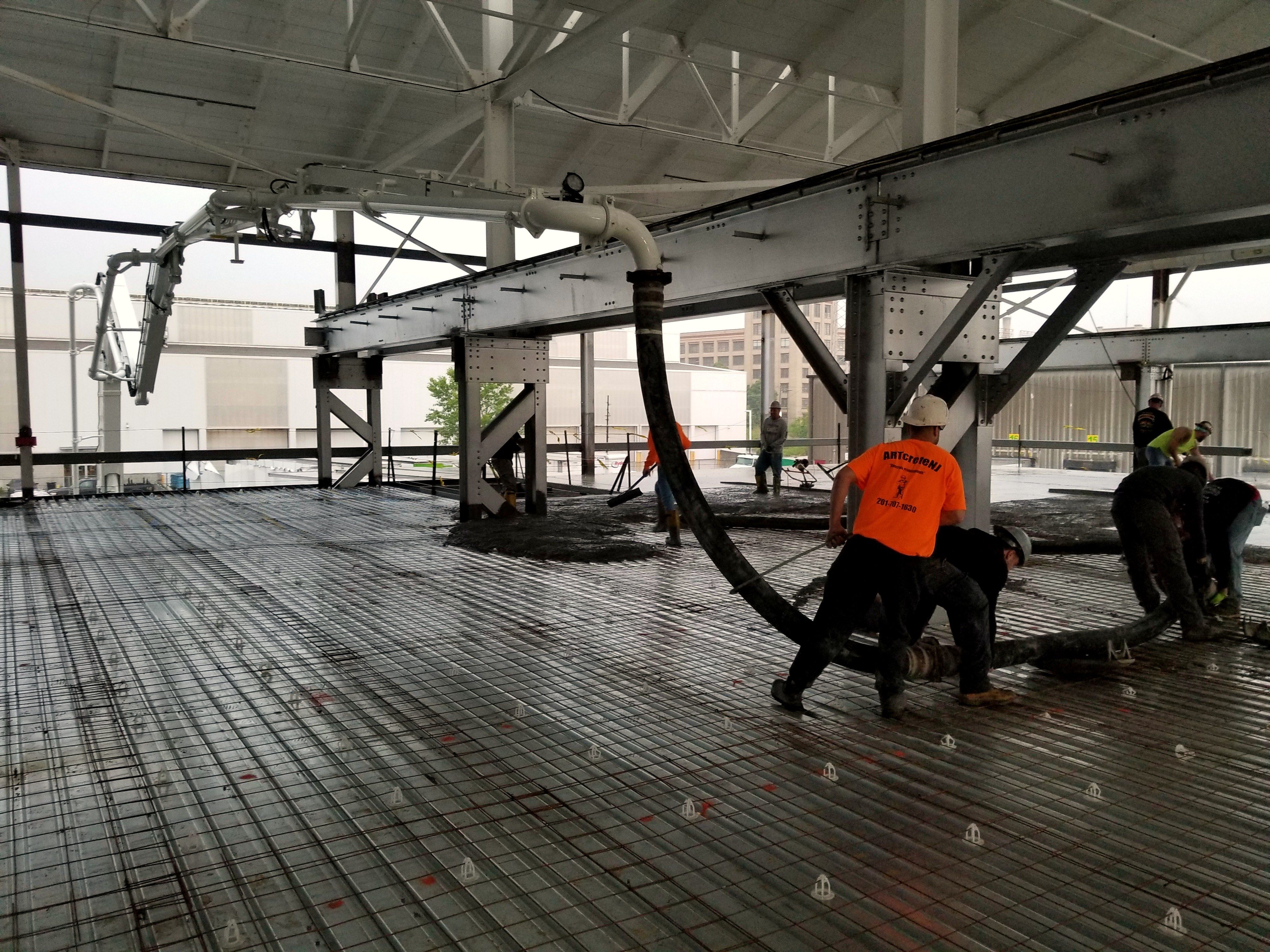 Crew placing concrete with the end hose on an elevated deck