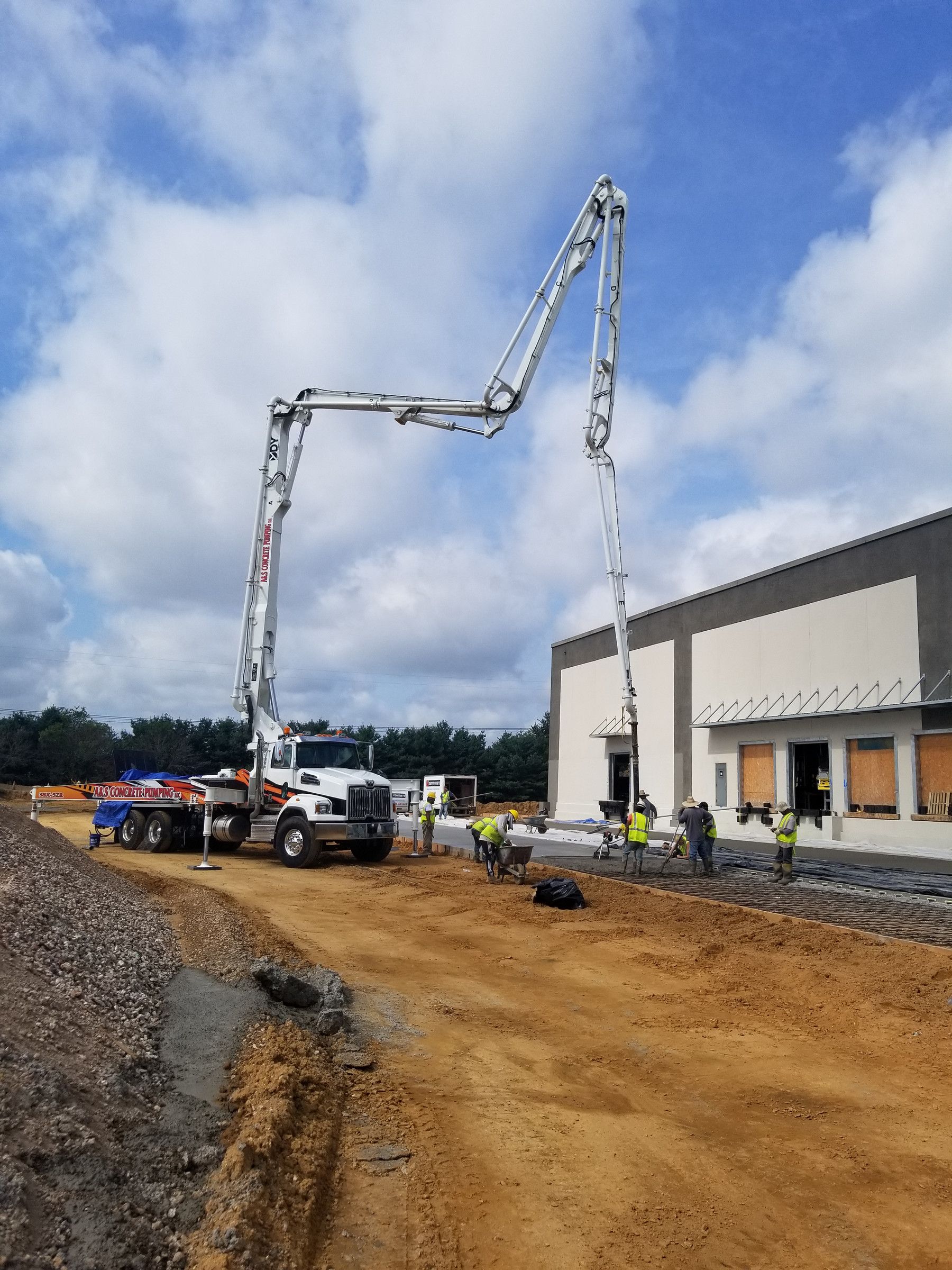 A&S Concrete Pumping DY 38X-5ZR boom pump placing a slab beside a new commercial building