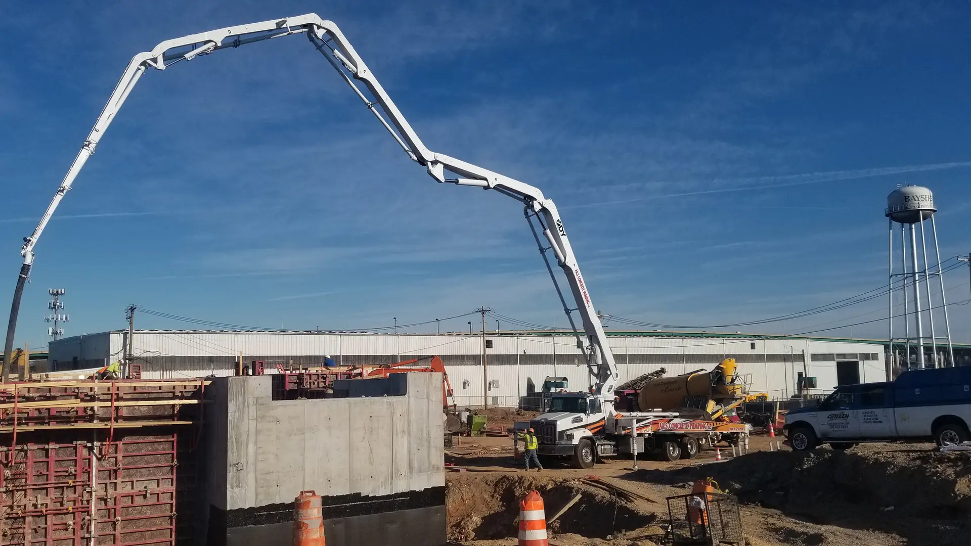 A&S boom pump reaching over tall wall forms at a large site