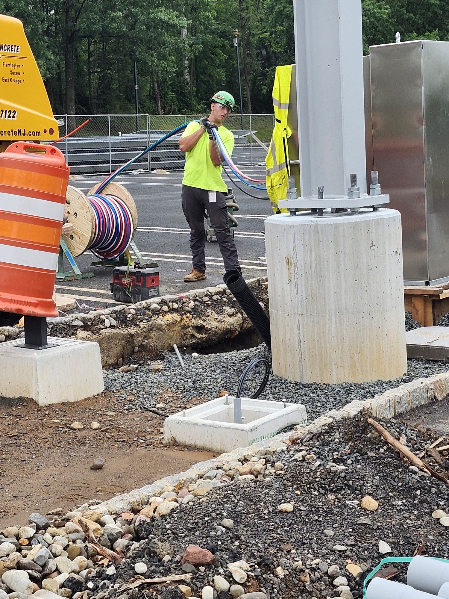 Crew member guiding a concrete line hose into a footing form