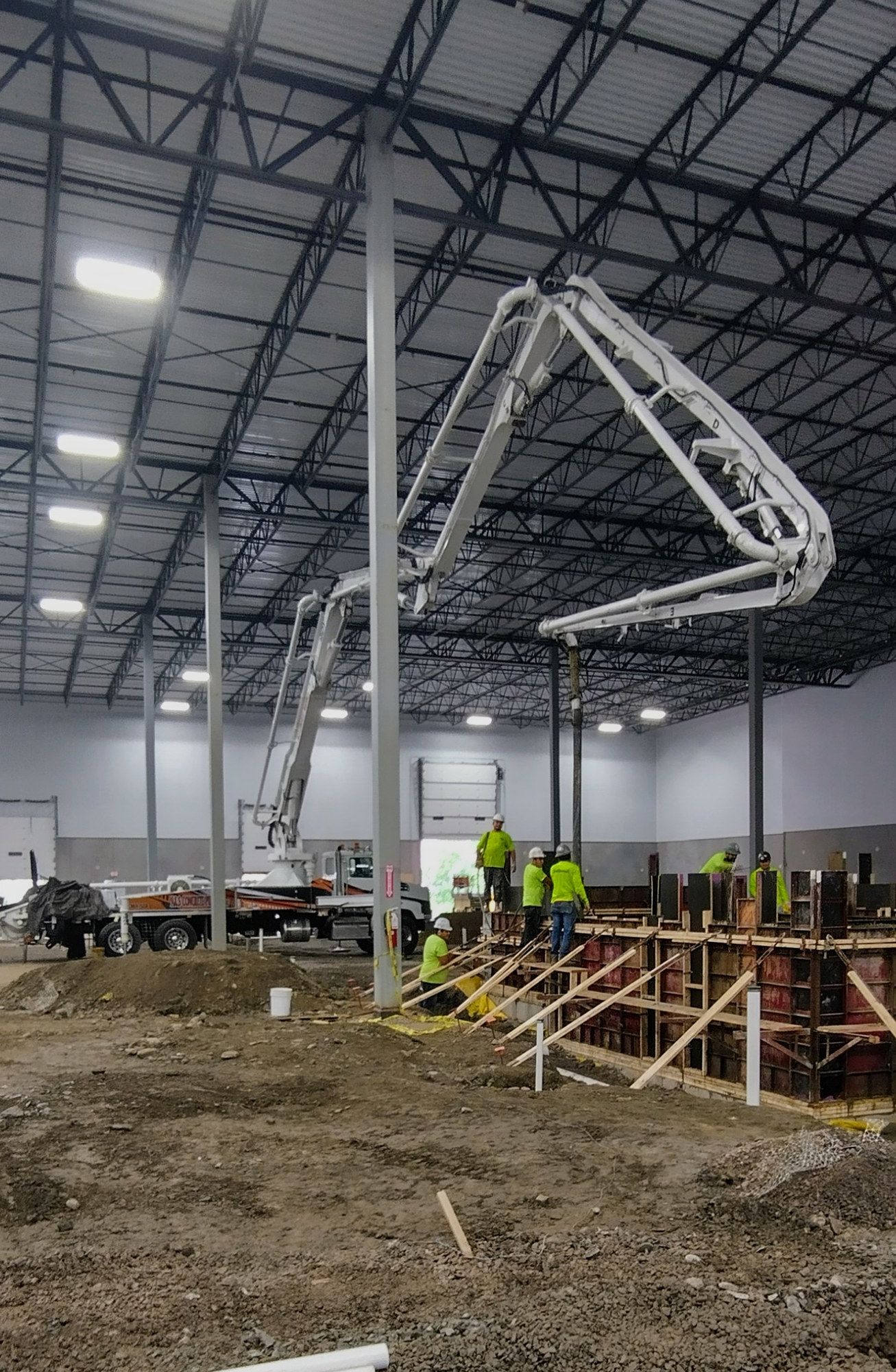 A&S boom pump placing concrete inside a large steel-framed building